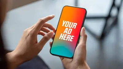 Hands holding a phone showing a YOUR AD HERE screen