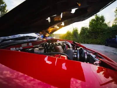 Car with its hood open showing the engine
